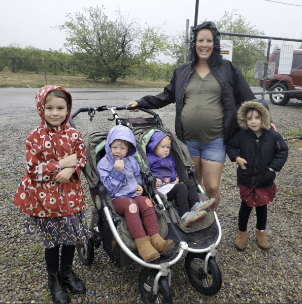 Family with stroller and young children at the farm